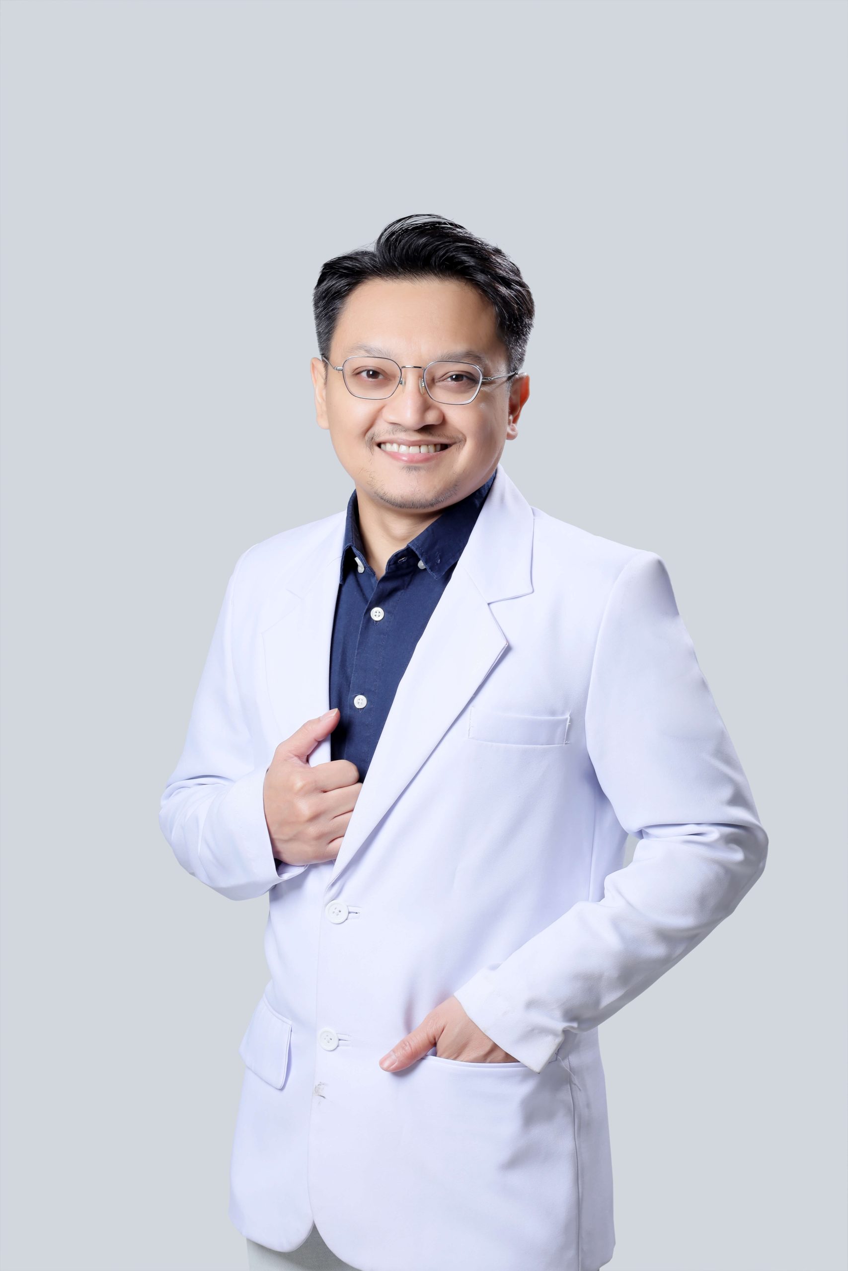 dr. Heri Noviana, dokter bedah plastik, tersenyum dengan jas putih